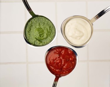 Ladles of tomato , pesto and mornay sauces