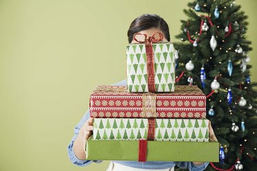 Woman with face covered by stack of presents