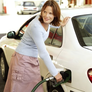 portrait of a young woman filling her car with petrol