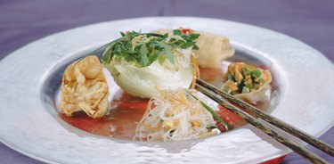 Dim sum and noodles with chopstick on plate, close-up