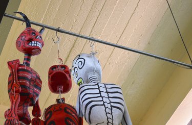 Catrina and devil hanging from ceiling at mexican market