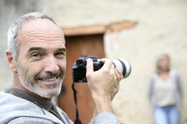 Happy paparazzi photographer taking pictures of woman