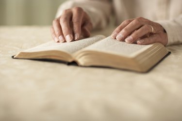 Senior man reading Bible, close-up of hands