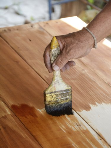 carpenter s hands paintbrush varnish to wood table