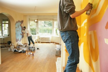 Two men painting wall, side view