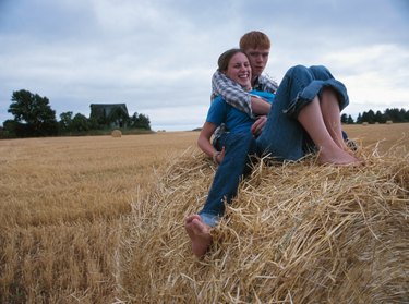 Couple cuddling on haystack