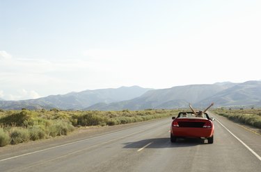 Carefree couple driving convertible on desert road