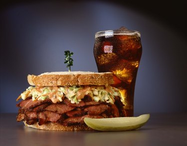 Pastrami sandwich with soft drink and pickle