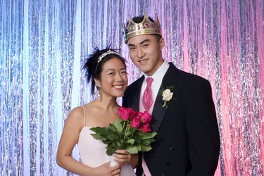 Prom queen holding flowers with king