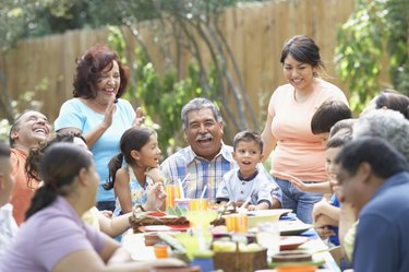 Three generation family sitting at a picnic table