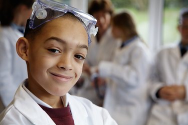 Schoolboy (8-10) in science class, smiling, portrait (focus on boy)