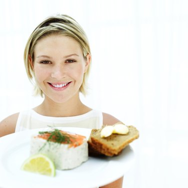 Portrait of a woman holding a plate of pate and sliced bread