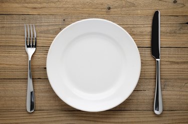 Plate, fork and knife on wood