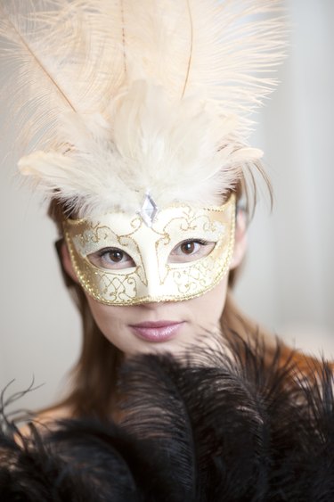 Portrait of young woman wearing ornate mask