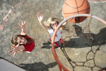 Two young women playing basketball