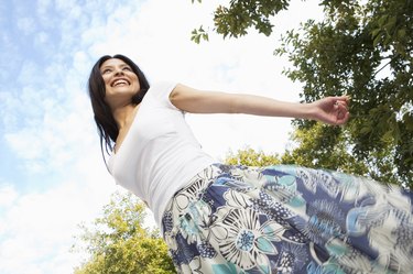 Happy young woman being playful at the park