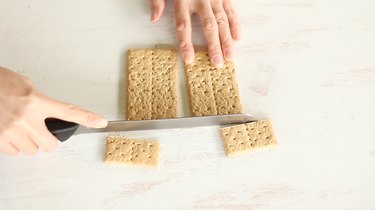 Slicing bottom fourth off two crackers