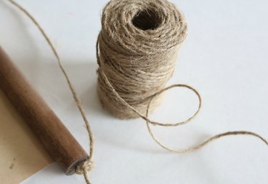Thread twine or rope through eye hooks and tie to make a loop.