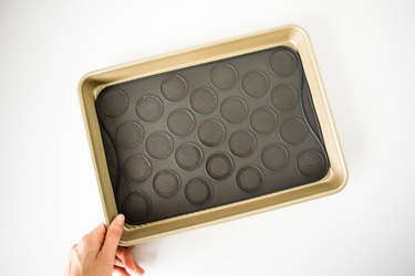 Baking tray lined with silicone macaron slip-mat.