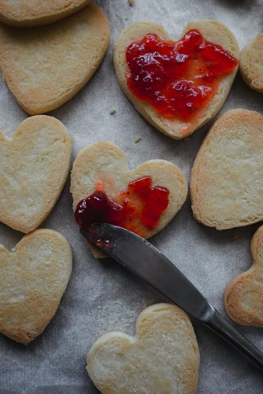 Use a knife to spread the jam over the cookie bases.