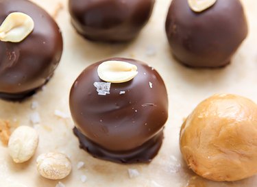 No-Bake Chocolate Peanut Butter Balls topped with sea salt and a peanut.