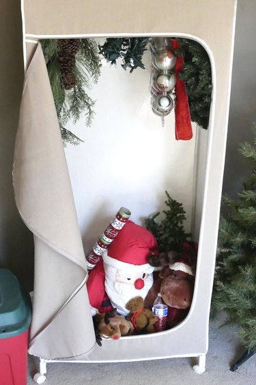Christmas decorations tucked in portable canvas closet.