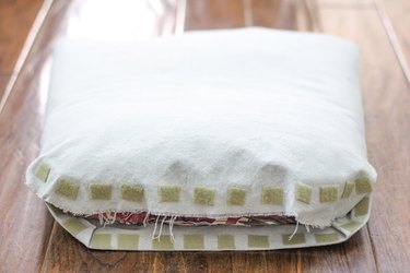 Hook-and-loop fastener attached to the top and bottom flaps of fabric in the back of the cushion