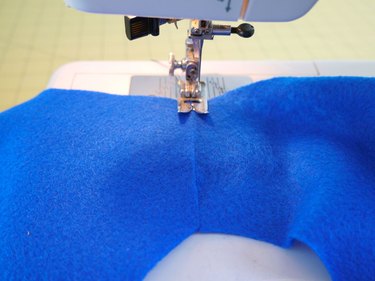 The shoulder ends of the vest loaded in a sewing machine.