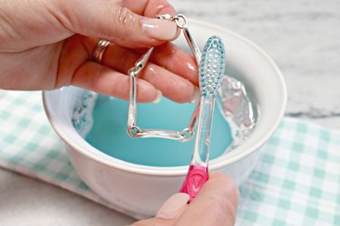 Scrubbing jewelry with toothbrush