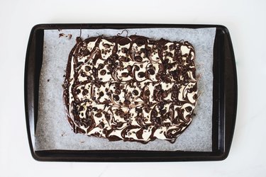 Additions sprinkled onto the chocolate slab.