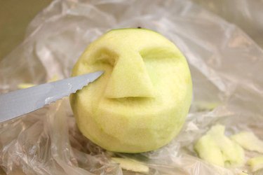 Carve a face in the peeled apple