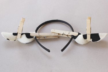 ...A DIY cow ear headband with clothespins holding the ears in position while glue dries