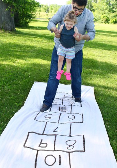 father and little girl playing hopscotch