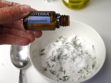 Adding essential oil to one of the mixing bowls.
