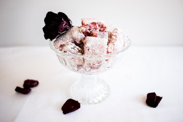 Dish of Turkish delight topped with rose petals.