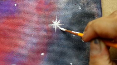 Painting a star on a cushion cover.