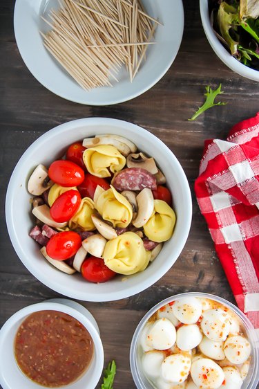 In a bowl combine the tortellini, cheese, salami, tomatoes, and mushrooms.