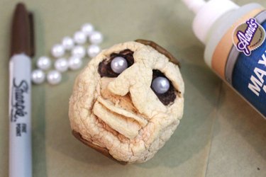 Decorated eyes on the dried-apple shrunken head