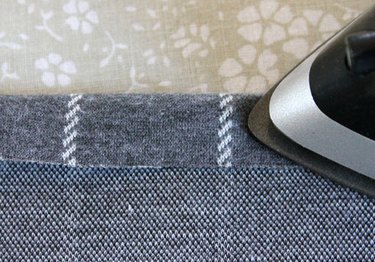 Use an iron to press the hem to the wrong side of the fabric.