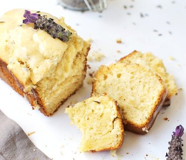 A sliced loaf of lavender lemon ice cream bread topped with lavender flowers