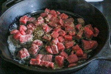 Beef in a skillet with seasoning