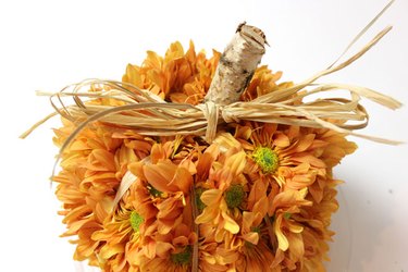 A raffia bow gives this faux pumpkin a very real warmth