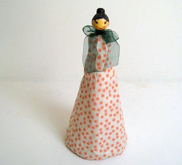 Lady Cheese Grater dressed in tissue paper with a bow tied around her neck