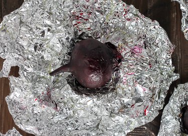 Unwrapped foil holding a roasted beet.