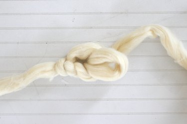 reach hand through loop and pull yarn through to create another 4 inch loop