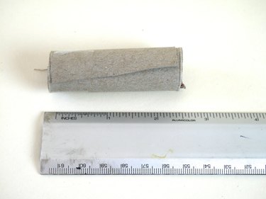 A roll of cardboard measuring 2 1/2 inches, and a ruler.