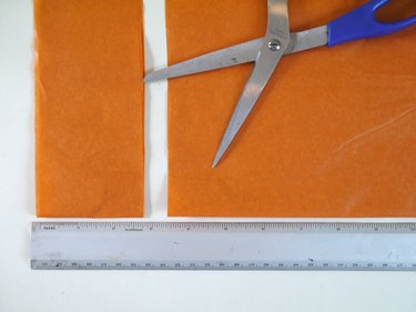 A sheet of tissue trimmed into a 2 1/2 inch strip, a ruler and scissors.