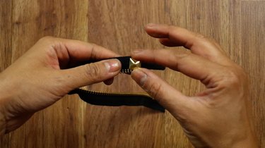 Applying a stud to a zipper bracelet.