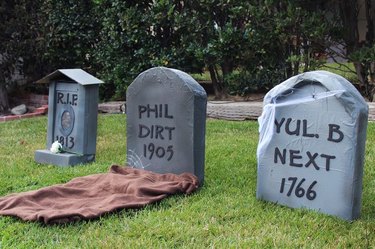 Three cardboard tombstones with silly names