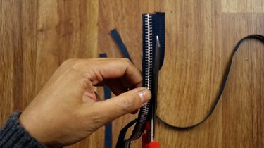 Cutting excess material from zipper.
